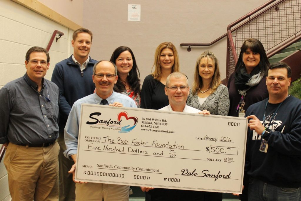 Teacher Kevin Ingram (left center), Dale Sanford (owner of Sanford Temperature Control; right center), and faculty of Milford Middle School.